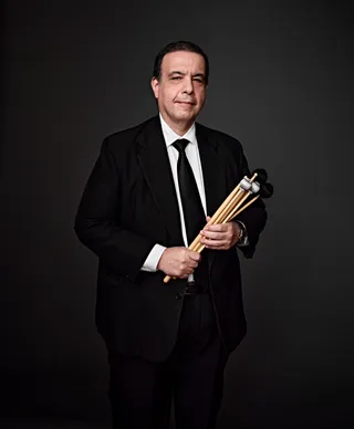 Alfredo Lima is a white man with brown hair. He is wearing a white shirt, a black tie, and a black blazer.