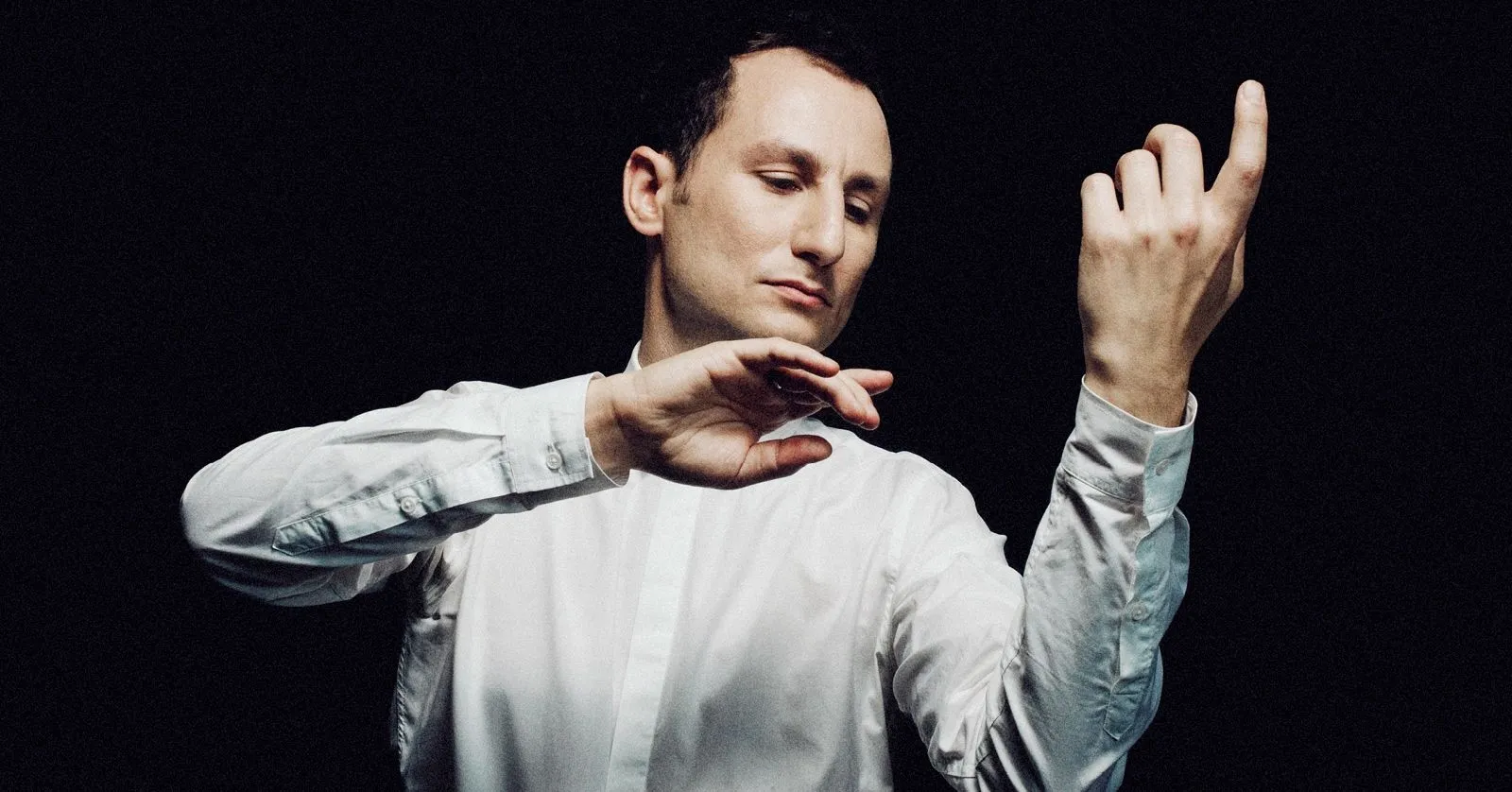 Antoine Tamestit é um homem branco, de cabelos castanhos curtos. Ele está de perfil e segura uma viola.