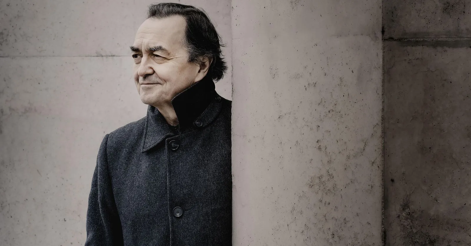 Pierre é um homem branco, de cabelos pretos penteados para trás. Ele usa um casaco de frio e está de perfil na foto.