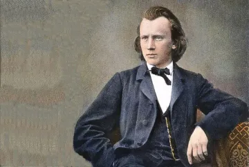 pintura de johannes brahms, homem branco, adulto, de cabelos castanhos e longos. Eles veste paletó e gravata. A pintura mostra apenas seu busto, mas é possível ver que ele está sentado e tem um dos braços apoiados.